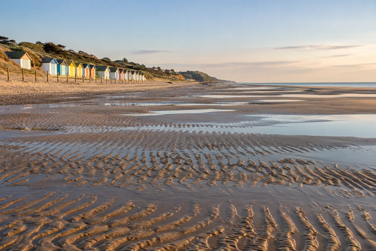 Plage de sable à marée basse avec cabines de plage colorées
